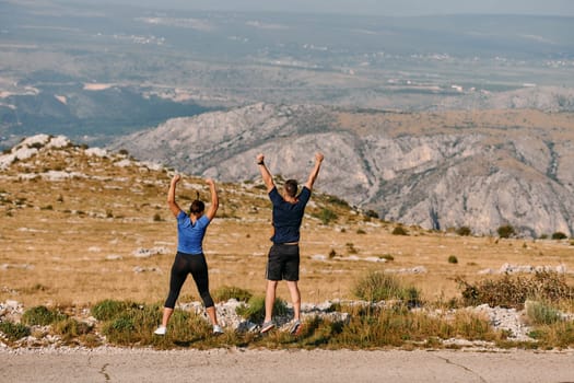 A jubilant couple celebrates their triumphant finish after a challenging morning run, exuding happiness and unity amidst the refreshing outdoor scenery.