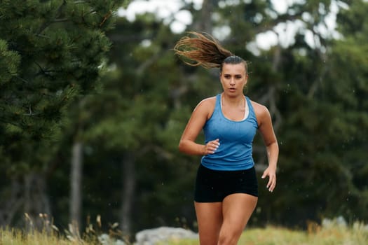 Rain or shine, a dedicated woman powers through her training run, her eyes set on the finish line.