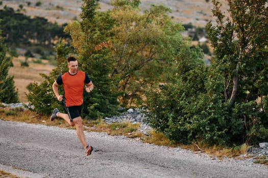 A muscular male athlete runs along a rugged mountain path at sunrise, surrounded by breathtaking rocky landscapes and natural beauty.