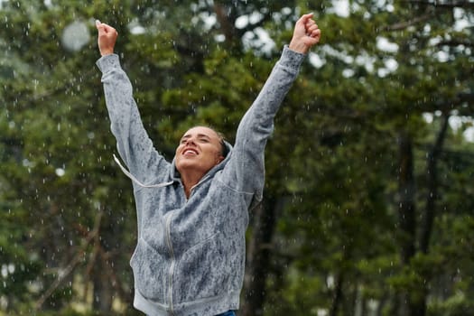 A stunning woman savors the tranquility of a rainy day after a rigorous run, finding solace and rejuvenation in the soothing rhythm of the falling rain.