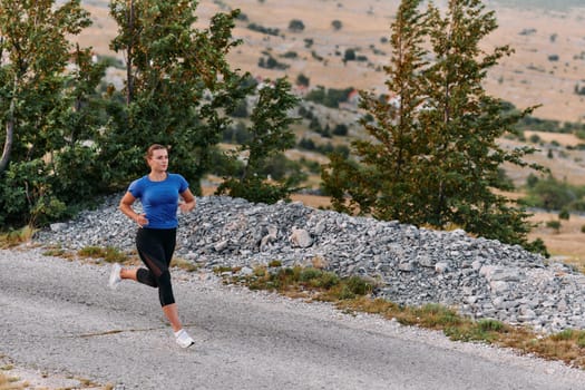 A determined female athlete runs through a forest trail at sunrise, surrounded by breathtaking natural beauty and vibrant greenery.