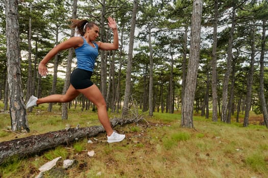 An intrepid woman fearlessly navigates through perilous forest terrain, effortlessly leaping over wooden obstacles with determination and grace, showcasing her adventurous spirit and athletic prowess