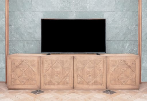 LCD led tv with blank black screen standing on wooden television cabinet