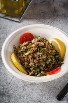 Healthy salad with capers, quinoa and walnuts on stone table