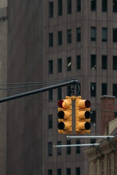 Traffic light showing red signal in downtown New York City with a background of tall buildings and skyscrapers.