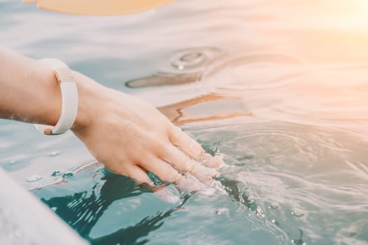 Woman in kayak back view. Happy young woman with long hair floating in transparent kayak on the crystal clear sea. Summer holiday vacation and cheerful female people having fun on the boat.