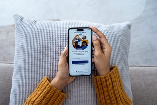 30 April 2023 Chiangmai, Thailand : Woman holding smartphone mobile show Microsoft Teams social platform, group chat platform app.