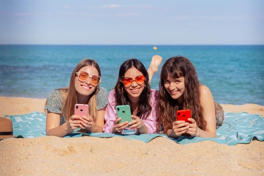 Group of smiling multiethnic women enjoying vacation. Beautiful and cheerful girls of generation z pose for a photo with a mobile phone.