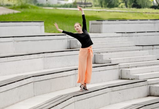 Sweet Girl Dances In Sandals At Amphitheater In Summer