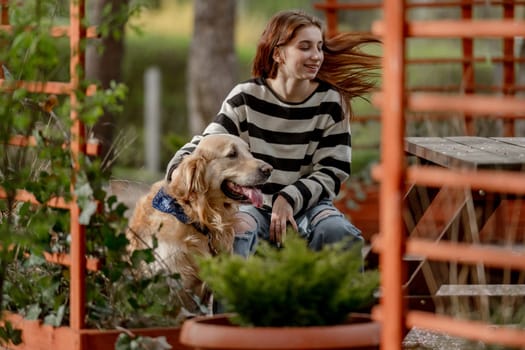 Teen Girl Plays With Golden Retriever In Gazebo During Spring
