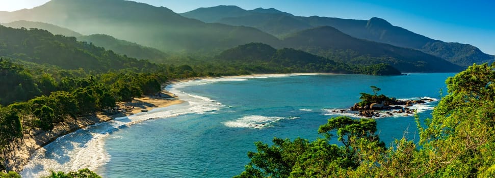 Panoramic image of Castelhanos beach between the sea, mountains and forests of the island of Ilhabela on the coast of Sao Paulo