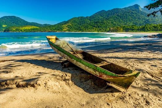 Primitive wooden fishing canoe on the sands of Castelhanos beach in Ilhabela