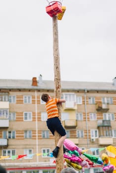 VICHUGA, RUSSIA - MARCH 12, 2016: Celebration of the Russian Slavic holiday Maslenitsa. Traditional competitions on climbing the pole for gifts
