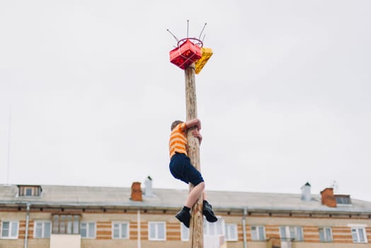 VICHUGA, RUSSIA - MARCH 12, 2016: Celebration of the Russian Slavic holiday Maslenitsa. Traditional competitions on climbing the pole for gifts