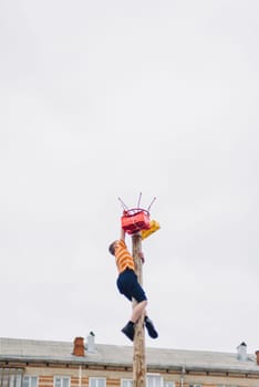 VICHUGA, RUSSIA - MARCH 12, 2016: Celebration of the Russian Slavic holiday Maslenitsa. Traditional competitions on climbing the pole for gifts