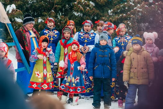 VICHUGA, RUSSIA - FEBRUARY 17, 2018: crowd of girls on stage sing songs in traditional Slavic costumes at the winter Russian celebration of the Maslenitsa holiday