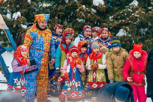 VICHUGA, RUSSIA - FEBRUARY 17, 2018: crowd of girls on stage sing songs in traditional Slavic costumes at the winter Russian celebration of the Maslenitsa holiday