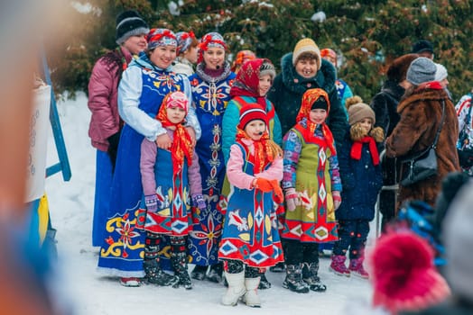 VICHUGA, RUSSIA - FEBRUARY 17, 2018: crowd of girls on stage sing songs in traditional Slavic costumes at the winter Russian celebration of the Maslenitsa holiday