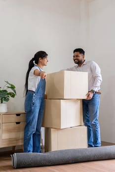 Arab couple moving into their new home, carrying boxes and unpacking together. Modern lifestyle and family bonding.