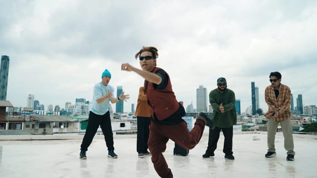 Professional break dance team practice B-boy dance while multicultural friends at rooftop. Young modern dancing group doing hip hop movement. Style,fashion,action. Outdoor sport 2024. Endeavor.