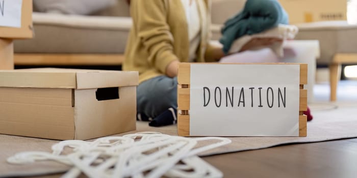 Volunteers sorting and donating clothes for charity, showcasing community service and generosity.