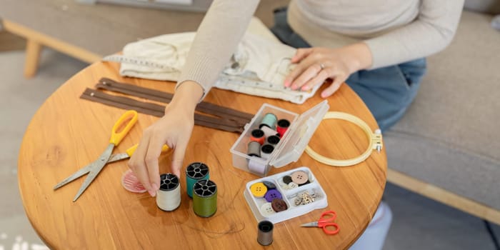 A volunteer mending clothes for donation and recycling, emphasizing sustainable fashion and community support through repairing and reusing garments.