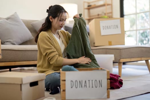 Volunteers sorting and donating clothes in a modern living room, showcasing community support and generosity.