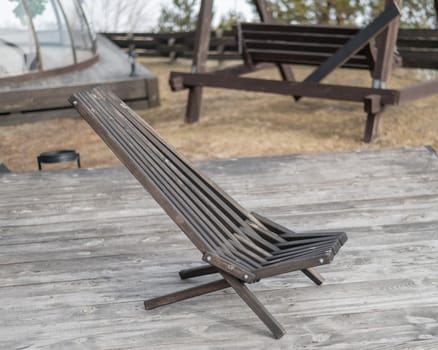 Empty wooden deck chair outdoors