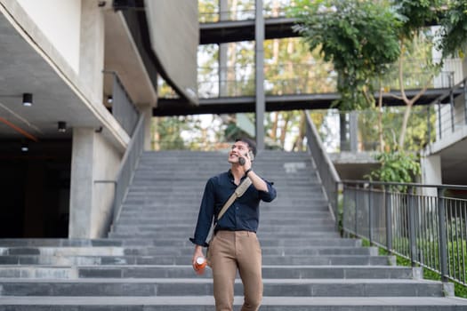 Businessman walking with a reusable eco-friendly cup, showcasing sustainable lifestyle choices in a modern urban environment.