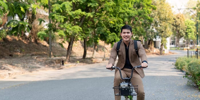 A businessman in a suit rides a bicycle through a park, promoting eco-friendly and sustainable commuting options.