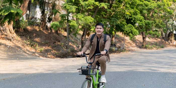 Businessman commuting on a bicycle in an urban environment, showcasing eco-friendly and sustainable transportation options.