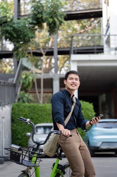 Businessman on a bicycle working outdoors, showcasing eco-friendly transportation and a modern urban lifestyle.