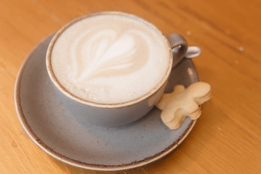 Coffee on a wooden table in a cafe, drawings on coffee
