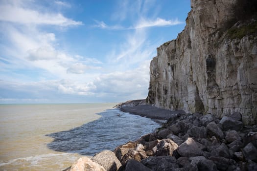 the chalk cliffs of etretat in France in Normandy with a blue sky with white clouds and the sea