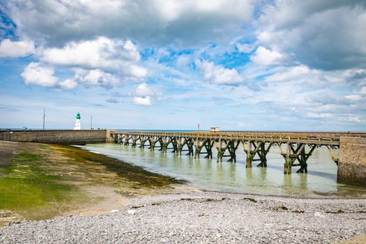 old wooden bridge and lighthouse in the harbor of the french vilage of treport in Normandy