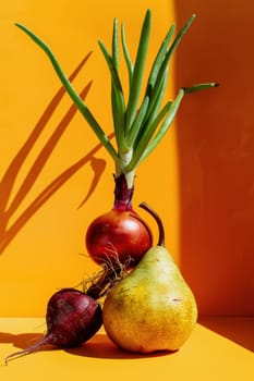 Fresh harvest two pears and an onion on yellow surface against orange wall