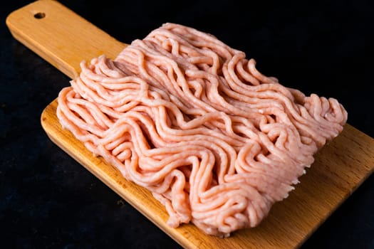 Minced meat on wood with fork. Fashionable photo of minced meat with space for text.