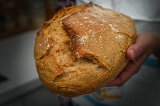 Woman holding freshly baked bread on black background, closeup 2