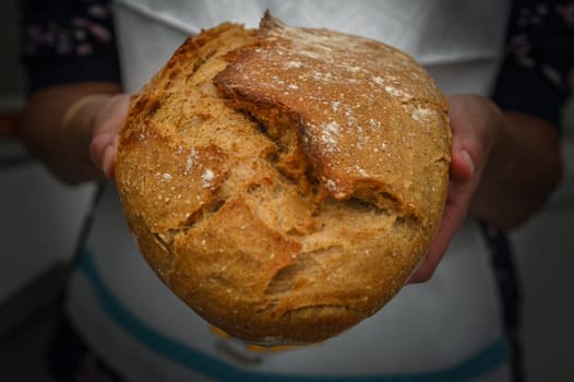 Woman with fresh baked sourdough bread in kitchen 2