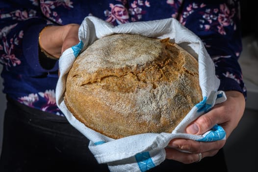 Traditional leavened sourdough bread in baker hands on a rustic . Healthy food photography 2