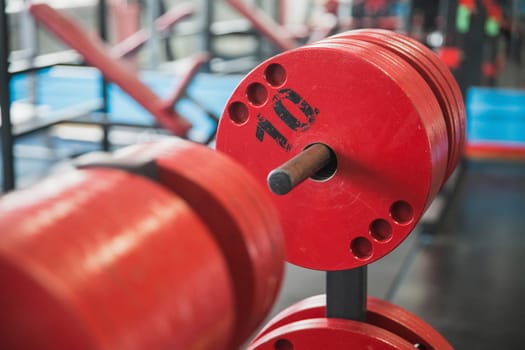 Plates to the barbell in the gym.