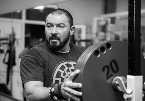 Bila Tserkva, Ukraine, October 15, 2016: Man squats with a barbell in the gym