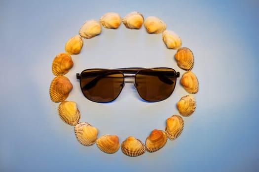 Sunglasses in a circle of shells. High quality photo