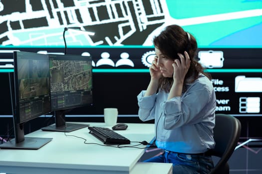 Woman operator works in call center to ensure fast order delivery to clients, handling any delay complains. Employee finding alternative routes for couriers to avoid heavy traffic via radar.