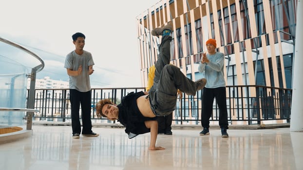 Hip hop team dance break dance while multicultural friend surrounded and clapping hands to cheer or encourage his friend to dance. Active and energetic street dance. Outdoor sport 2024. Endeavor.