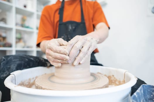 Close-up of a potter's hands working on a pottery wheel