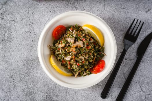 Healthy salad with capers, quinoa and walnuts on stone table