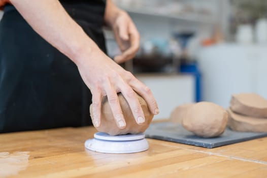 A potter kneads clay before using it in the workshop. Close-up of a man's hands