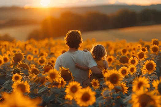 A man and a child stand in a field of sunflowers as the sun sets.