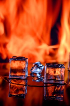 three ice cubes against the background of fire, fire and ice, place under the text